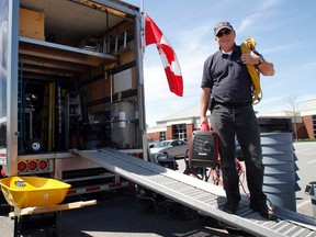 Samaritan's Purse regional representative Stephen Elliott carries generators and electric cords outside the non-profit, Christian charity's mobile headquarters at Maranatha Christian Reformed Church in Belleville, Ont. Monday, May 5, 2014. - JEROME LESSARD/THE INTELLIGENCER/QMI AGENCY