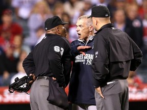 Manager Joe Girardi of the New York Yankees gestures and shouts at home plate umpire Laz Diaz as second base umpire Jeff Nelson looks on after Girardi was ejected for arguing a strike call in the eighth inning against the Los Angeles Angels of Anaheim at Angel Stadium of Anaheim on May 5, 2014 in Anaheim, California. (Stephen Dunn/Getty Images/AFP)
