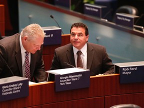 Councillors Giorgio Mammoliti and Doug Ford switch seats and Mammoliti sits  in Mayor Rob Ford's chair at a meeting of city council on Tuesday. (MICHAEL PEAKE/Toronto Sun)