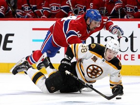 Tomas Plekanec of the Montreal Canadiens goes airborne as he battles for the puck against Jordan Caron of the Boston Bruins in Game 3 at the Bell Centre on May 6, 2014. (Francois Laplante/Freestyle Photography/Getty Images/AFP)