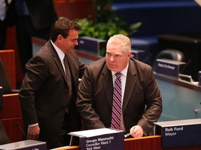 Councillors Giorgio Mammoliti and Doug Ford switch seats and Mammoliti sits  in Mayor Rob Ford's chair at a meeting of Toronto City Council , the first with Mayor Rob Ford in rehab  on Tuesday May 6, 2014. Michael Peake/Toronto Sun/QMI Agency