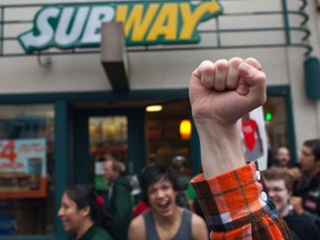 Stephen Baldwin holds his fist in the air outside a Subway restaurant during a strike aimed at the fast-food industry and the minimum wage in Seattle, Washington August 29, 2013. (REUTERS/David Ryder)