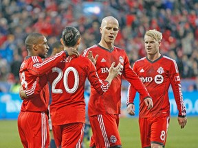 Toronto FC forward Jermain Defoe (left) celebrates his first-half goal against Vancouver with teammates on Wednesday night. (USA TODAY SPORTS)