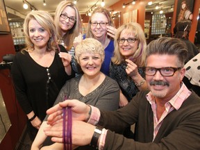 From left to right: Lianne Tregobov, Michelle Johnson, Susan Livingston, Shelley Torz and Mancy Mutchmor display their purple hair extensions with Hair FX founder Michael Larocque as part of a cancer awareness campaign called Purple Streak for Power. (Brian Donogh/Winnipeg Sun)