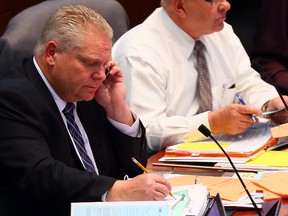 Councillor Doug Ford works the phone during council's meeting at City Hall on Wednesday. (DAVE ABEL/Toronto Sun)