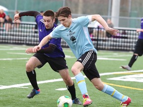 Shawn Wilcox of the St. Benedict Bears is the game changer of the week here he fights for the ball with Aristo Koutsoukis of the Lo Ellen Knights during Thursday afternoon soccer action from James Jerome Field.