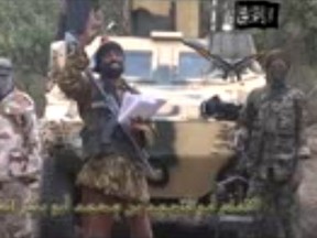 A frame grab made on May 5, 2014, from a video obtained by AFP, shows the Islamist extremist group Boko Haram leader  Abubakar Shekau, centre, delivering a speech.
 AFP PHOTO/BOKO HARAM