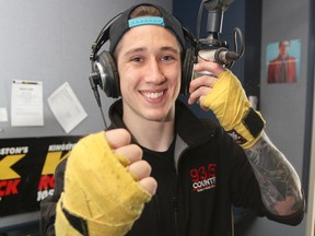 PJ Ste. Marie, promotions co-ordinator at K-Rock 105.7, won his fourth consecutive mixed martial arts fight on May 3 in Watertown, N.Y. Ste. Marie poses with some of his fighting gear in the K-Rock broadcast booth on Thursday. (Julia McKay/The Whig-Standard)