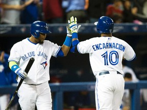 Toronto Blue Jays first baseman Edwin Encarnacion is greeted by third baseman Juan Francisco after hitting a home run against the Philadelphia Phillies at the Rogers Centre in Toronto, May 8, 2014. (JACK BOLAND/QMI Agency)