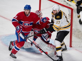 Boston Bruins’ Milan Lucic battles for position in front of Canadiens goalie Carey Price as Montreal’s Alexei Emelin tries to clear the crease last night in Game 4. The Bruins won 1-0 in overtime on a goal by Matt Fraser. (Pierre-Paul Poulin, QMI Agency)