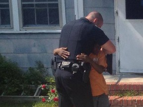 Officer Gaetano Acerra of the Sumter Police Department in South Carolina gets a hug from a 13-year-old boy after Acerra convinced the boy not to run away from home, and gave the teen a proper bed, a desk, TV, chair and a Wii. This photo was posted to Facebook by Acerra's brother, Ferdinando Acerra. (Photo: Facebook/Handout/QMI Agency)