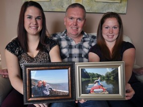 Sisters Melanie MacDonald (left) and Diana MacDonald sit with dad, Jamie, while holding photos of their late grandparents, Gord and Gladis, at home in London, Ont. May 7, 2014. Inspired by their grandparents’ humanitarian efforts, the family is trying to raise $5,000 for Plan Canada by climbing Mount Kilimanjaro at the end of June. CHRIS MONTANINI\LONDONER\QMI AGENCY