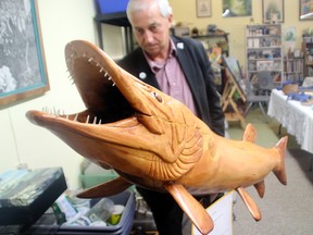 Mayor Dave Canfield examines one of the Muskies on Main entries at a sneak peek event Wednesday evening, May 7. Artists, dignitaries and journalists got the first look at the handmade muskie statuettes which will be installed as a public art display at several downtown locations this summer.