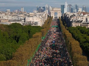 Racers run down the Champs Elysees below the Arc de Triomphe at the start of the 38th Paris Marathon April 6, 2014.  GONZALO FUENTES/REUTERS