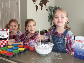 Four-year-old Carolyn Lenkenhoff (right) bakes Phe-free cookies with her sisters Sophia (left) and Naomi at home in Spruce Grove on April 5. Carolyn has a rare metabolic disorder, PKU, that was detected in the first few days of her life because of a heel prick test that is available to all Canadian newborns.
