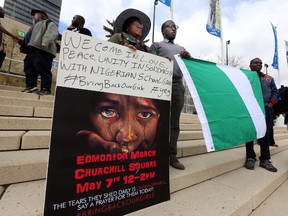 People hold a protest signs to free kidnapped school girls in Nigeria during a rally at Churchill Square in Edmonton on May 7, 2014. (Perry Mah/QMI Agency)