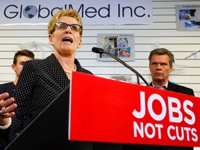 Ontario Premier Kathleen Wynne, speaking at GlobalMed Inc. in Trenton, Ont., Friday, May 9, 2014, attacks Tim Hudak's pledge to cut 100,000 public-sector jobs if he's elected. "You don't create jobs by cutting jobs," she said. At right is GlobalMed vice-president Al Flieler. (QMI Agency)