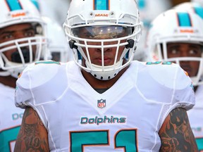 Mike Pouncey of the Miami Dolphins leads the team onto the field during a pre-season game against the Jacksonville Jaguars at EverBank Field on August 9, 2013. (Mike Ehrmann/Getty Images/AFP)