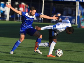 Montreal Impact midfielder Patrice Bernier gets tripped up by Eddies defensive midfielder Ritchie Jones during the first half in the first leg of the Amway Canadian Championship semi finals at Clarke Stadium in Edmonton, Alta., on Wednesday, May 7, 2014. Trevor Robb/Edmonton Sun/QMI Agency