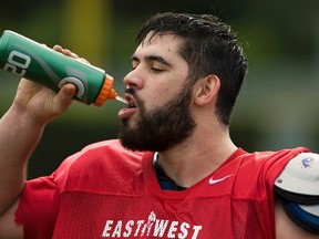 Offensive tackle Laurent Duvernay-Tardif of McGill University, who was selected in the NFL draft on Saturday, takes a water break during practice at a local high school field in St. Petersburg, Florida on January, 15, 2014. (QMI Agency)