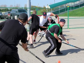 Jeff Drexler (in green) and Jeff Pauley (in white) of the Sarnia Fish Hookers road hockey team look to block a shot while goaltender Sean Parker looks on during the adult championship game of the Hiawatha 3-on-3 road hockey tournament this past Saturday. The Fish Hookers came back from a 3-1 deficit to defeat Pulling The Goalie 7-5 for the title. SHAUN BISSON/THE OBSERVER/QMI AGENCY