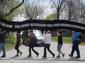 Protesters march along the St. Clair Parkway during a "Defend Our Climate, Defend Our Communities" National Day of Action rally Saturday. More than 40 people participated in the Toxic Tour through Chemical Valley in an effort to raise awareness about the impact they say industry has had on Aamjiwnaang First Nation.
