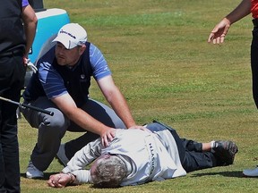 Caddie Ian McGregor lies on the grass near his player Scotland's Alastair Forsyth during the Madeira Golf Open in Santo da Serra May 11, 2014. McGregor, 52, from Zimbawe, suffered a heart attack on the ninth hole, according to media reports.  (REUTERS/Octavio Passos)