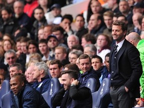 Tottenham Hotspur's English Manager Tim Sherwood (R) invites an unidentified spectator (C)  to take his seat in the dugout during the English Premier League football match between Tottenham Hotspur and Aston Villa at White Hart Lane in London on May 11, 2014. (AFP PHOTO/CARL COURT)