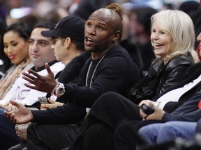 U.S. boxer Floyd Mayweather Jr. talks with an official as he sits courtside with Shantel Jackson, Los Angeles Clippers owner Donald Sterling and Sterling's wife Shelly at a game between the Chicago Bulls and Los Angeles Clippers on December 30, 2011. (REUTERS/Danny Moloshok)