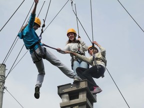 From left: Niki Smith, Monica DeFinney and Michie Gdanski try to step from one wooden square to the next, placing planks in between as part of co-operative exercise at Spencer Lodge in London. (KELLY PEDRO, The London Free Press)