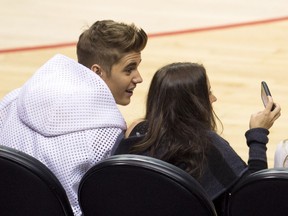 Justin Bieber takes a selfie with his mother Pattie Mallette at game 4 of the NBA playoff series between the Los Angeles Clippers and the Oklahoma City Thunder, May 11, 2014, at Staples Center in Los Angeles, California.  AFP PHOTO / ROBYN BECK
