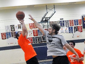 Travis Watson (left) of Rudy’s Rutabaga’s Raptors goes up for a jump shot despite being tightly defended by Dan Graul of Old ‘N Smooth during action from the 10th annual Mitchell Alumni basketball tournament May 3. Old ‘N Smooth pulled out a 42-36 victory. ANDY BADER/MITCHELL ADVOCATE
