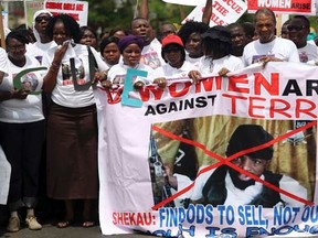 People carry a banner with an image of Boko Haram leader Abubakar Shekau as they protest for the release of the abducted secondary school girls in the remote village of Chibok, along a road in Lagos May 12, 2014.  REUTERS/Akintunde Akinleye