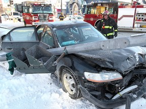 A Winnipeg firefighter examines a car involved in a two vehicle crash at Sherbrook and Ellice January 1, 2014. Two people were extricated and transported to hospital. (Brian Donogh/Winnipeg Sun files)