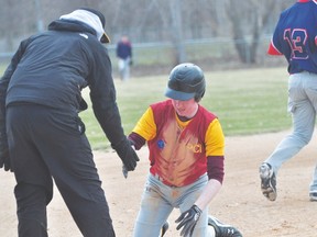 Quinn Ferris of the PCI Trojans baseball team is congratulated by manager Jay Dewis after sliding into third during the Trojans' doubleheader against Northlands Parkway Collegiate May 13. (Kevin Hirschfield/THE GRAPHIC/QMI AGENCY)