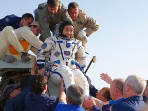 The International Space Station (ISS) crew member Japanese astronaut Koichi Wakata is helped by ground search and rescue personnel after landing south-east of the town of Dzhezkazgan in central Kazakhstan, May 14, 2014. (REUTERS/Dmitry Lovetsky/Pool)