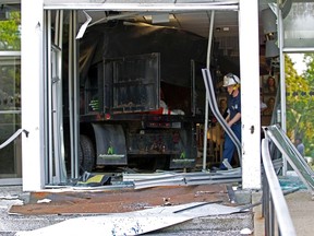 A Baltimore county firefighter walks out the broken door at the entrance of the WMAR-TV station in Towson, Md., on May 13, 2014. (REUTERS/Jose Magana)