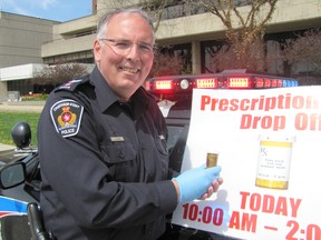 Sgt. Jim Lynds poses with one of prescription bottles dropped off on May 10.