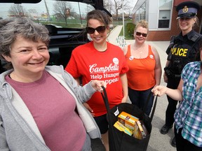 Christine Kramer (left) was among those contributing to the Tillsonburg Resource Network Bring It In Food Drive Saturday at The Livingston Centre, passing along a non-perishable food contribution accepted by (left to right) Devon Tamasi, Oxford County Public Health; Amanda Mueller, co-coordinator Bring It In Food Drive; Oxford OPP Constable Lisa Narancsik; and Tillsonburg Helping Hand Food Bank volunteer Tuesday Hughes. Jeff Tribe/Tillsonburg News