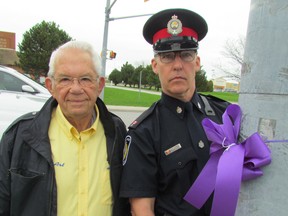 The Sarnia-Lambton Drug Awareness Action Committee launched this year's Purple Ribbon Campaign Wednesday to raise awareness of the dangers of drinking and driving. From left, committee member Art Speed and Sarnia Police Const. Les Jones hang a ribbon at the corner of Quinn and Barclay drives in Sarnia. PAUL MORDEN/ THE OBSERVER/ QMI AGENCY