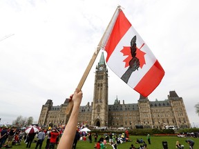 A First Nations protester holds a flag during the "National Day of Resistance" protest on Parliament Hill in Ottawa May 14, 2014. (REUTERS/Chris Wattie)