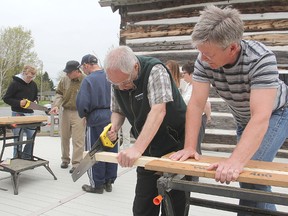 Instructor Clark Moffatt, right, keeps watch as intellectually disabled clients from a day program at Community Living Kingston work on a project to construct a wooden shelter at the MacLachlan Woodworking Museum.  MICHAEL LEA\THE WHIG STANDARD