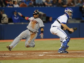 Indians third baseman Carlos Santana scores a run in the second inning as Blue Jays catcher Josh Thole awaits the throw during MLB action in Toronto on Wednesday, May 14, 2014. (Dan Hamilton/USA TODAY Sports)