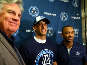 2014 draft pick Eric Black (centre) stands with his brother Matt Black (right) and Argos GM Jim Barke on Wednesday. (Dave Abel/Toronto Sun)