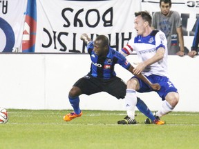 May 14, 2014; Montreal, Quebec, Canada; Montreal Impact midfielder Sanna Nyassi (11) and FC Edmonton defender Albert Watson (5) battle for the ball during the second half at the Stade Saputo. Mandatory Credit: Jean-Yves Ahern-USA TODAY Sports