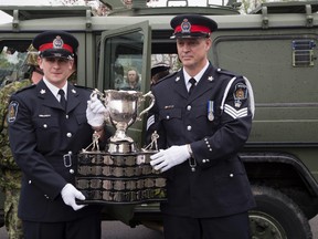 Two London police officers hold the Memorial Cups in London on Thursday. DEREK RUTTAN/ The London Free Press /QMI AGENCY