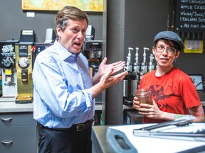 Mayoral candidate John Tory gets some coffee making tips from barista Kinga Nowak after making a policy announcement at Mountain View Coffee on Logan Ave. on Thursday. (ERNEST DOROSZUK/Toronto Sun)