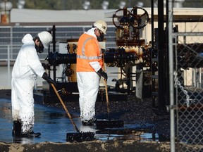 Workers clean up spilled oil at a facility in Los Angeles, May 15, 2014. Thousands of gallons of crude oil spilled over a half-mile area in Los Angeles on Thursday due to a break in an above-ground Plains West Coast pipeline, the city fire department said. (REUTERS/Phil McCarten)