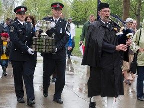 London police Const. A. J. Perry, left, and Sgt. Tom Allen parade the Cup past the Boer War Memorial in Victoria Park. (DEREK RUTTAN, The London Free Press)