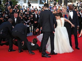 A man is arrested by security as he tries to slip under the dress of actress America Ferrera (3rdR) as she poses on the red carpet arriving for the screening of the film "How to Train Your Dragon 2" out of competition at the 67th Cannes Film Festival in Cannes May 16, 2014. From R, Cast members Djimon Hounsou, Cate Blanchett, America Ferrera, Kit Harington and Jay Baruchel. REUTERS/Benoit Tessier